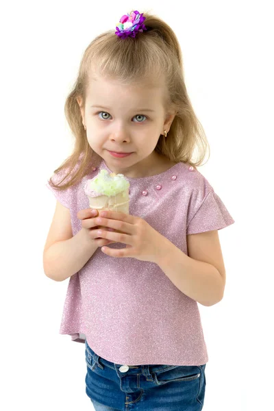 Klein meisje in casual outfit eten van ijs — Stockfoto