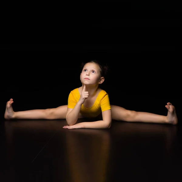 Cute young girl sitting on cross transverse splits — Stock Photo, Image
