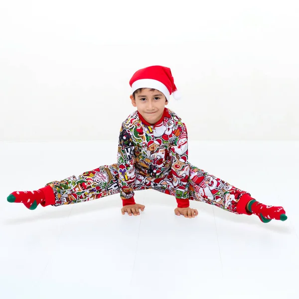 Мальчик в рождественском наряде делает стойку на руках и расщепляет — стоковое фото