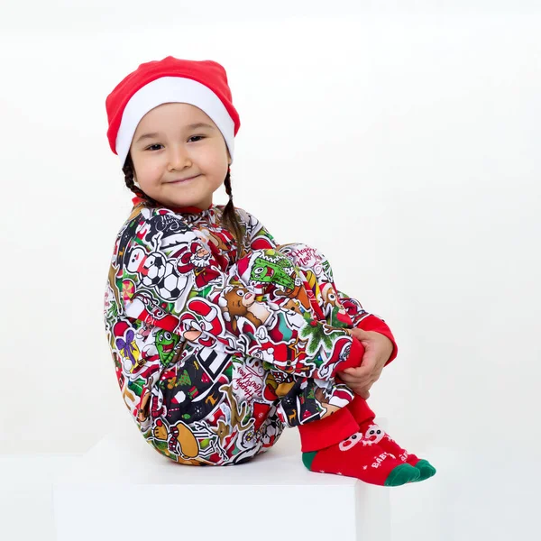 Menina feliz no traje de Natal sentado no chão Fotos De Bancos De Imagens