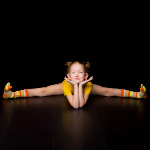 Słodkie szczęśliwy młoda dziewczyna gimnastyczka robi krzyż podział — Zdjęcie stockowe