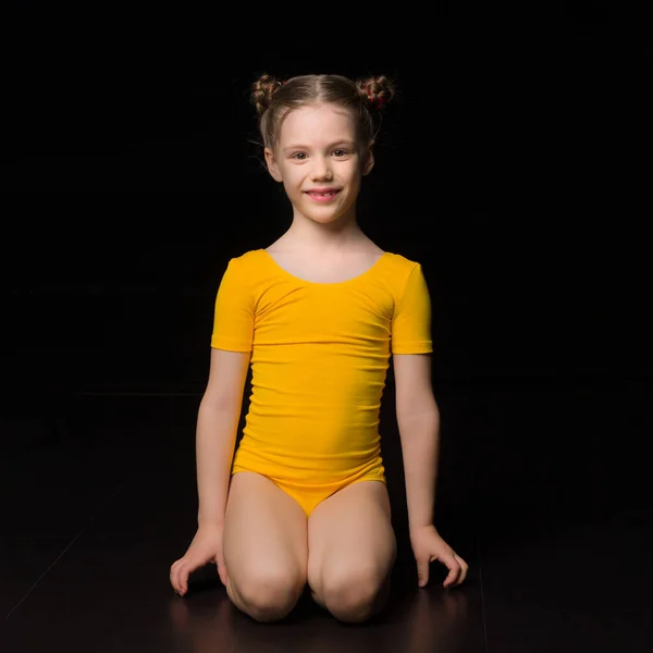 Roztomilá holčička gymnastka klečící na podlaze Stock Fotografie