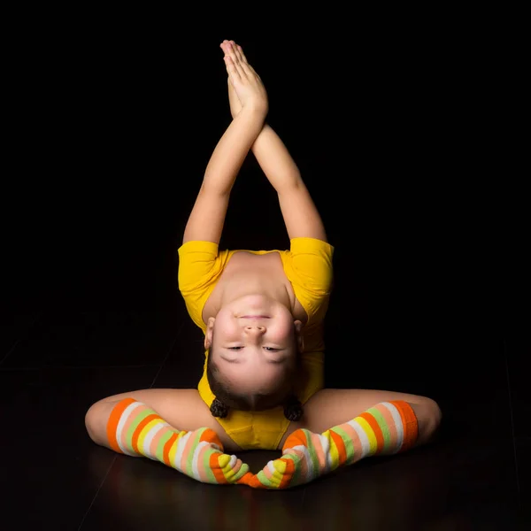 Schattig flexibel klein meisje acrobat doen acrobatische oefening Rechtenvrije Stockafbeeldingen