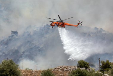 Atina, Yunanistan, 4 Haziran 2022: Atina 'nın Glyfada banliyösü yakınlarındaki Hymettus Dağı' nda bir itfaiye helikopteri faaliyet gösteriyor.