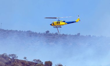Atina, Yunanistan, 4 Haziran 2022: Atina 'nın Glyfada banliyösü yakınlarındaki Hymettus' ta bir itfaiye helikopteri faaliyet gösteriyor..