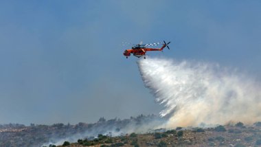 Atina, Yunanistan, 4 Haziran 2022: Atina 'nın Glyfada banliyösü yakınlarındaki Hymettus Dağı' nda bir itfaiye helikopteri faaliyet gösteriyor.