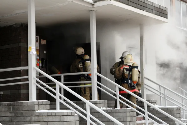 Equipo de bomberos en casa en llamas — Foto de Stock