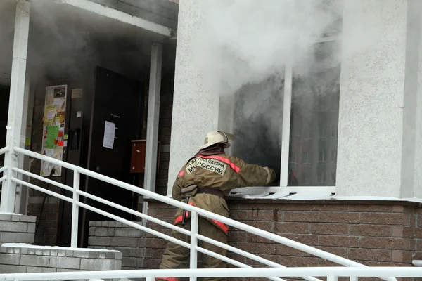 Firefighter at smoking window — Stock Photo, Image
