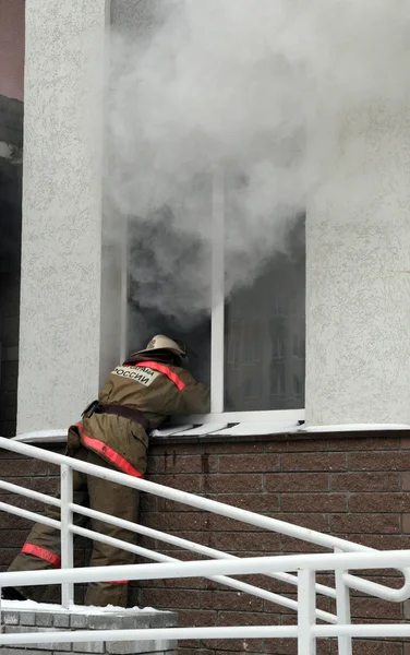 Fireman at smoking window — Stock Photo, Image