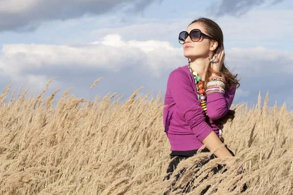 Young woman wearing jewellery and sunglasses looking aside — Stock Photo, Image