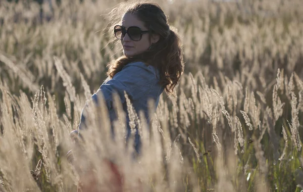 Молодая женщина в солнечных очках на поле — стоковое фото