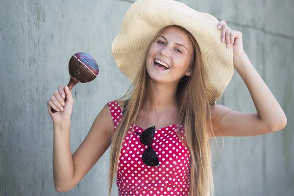 Beautiful smiling girl holding maracas and hat — Stock Photo, Image