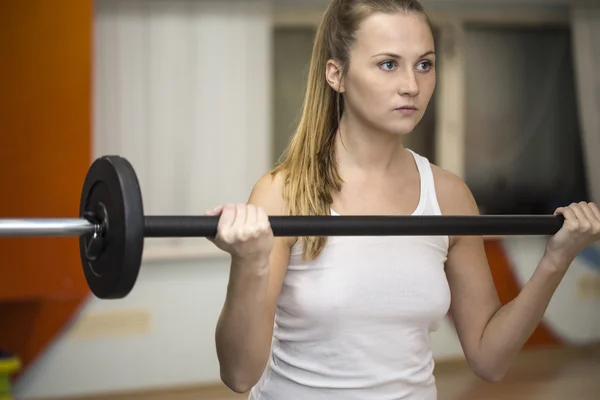 Jonge atleet blonde vrouw doen squats in gym — Stockfoto