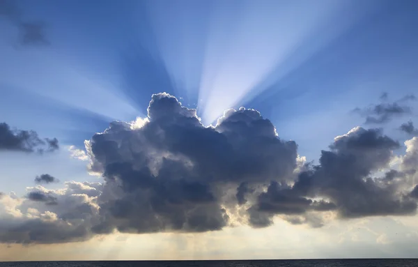Zonnestralen onder de wolken — Stockfoto