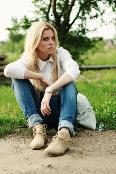 The woman sitting beside the road with a bag — Stock Photo, Image