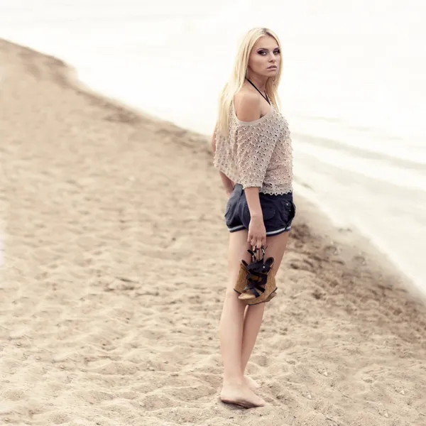 Mujer joven en vestido caminando sola en la playa — Foto de Stock