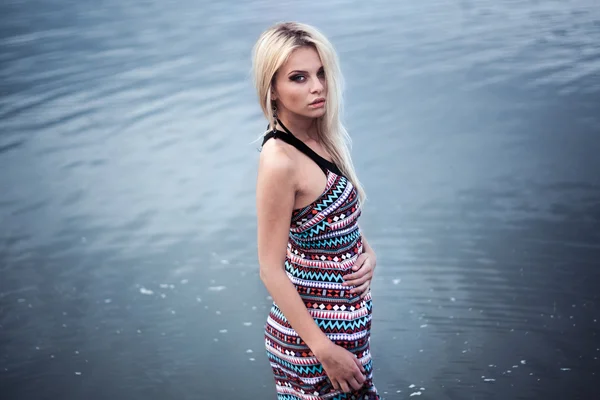 Jovem mulher de vestido andando sozinha na praia — Fotografia de Stock