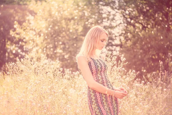 Modell flicka på fältet i solljus. långt hår — Stockfoto