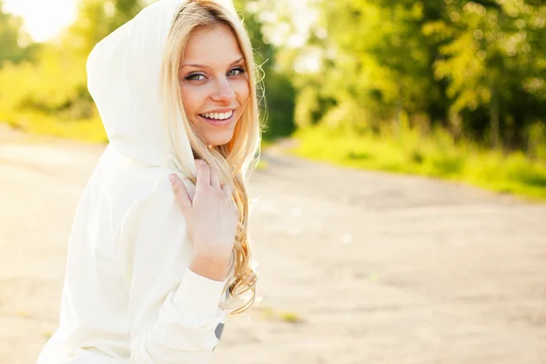 Niedliches lächelndes Mädchen draußen im Park, das dich ansieht — Stockfoto