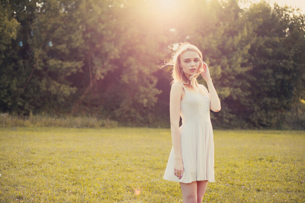 красивый портрет блондинки крупным планом на ярком дневном фоне в парке
