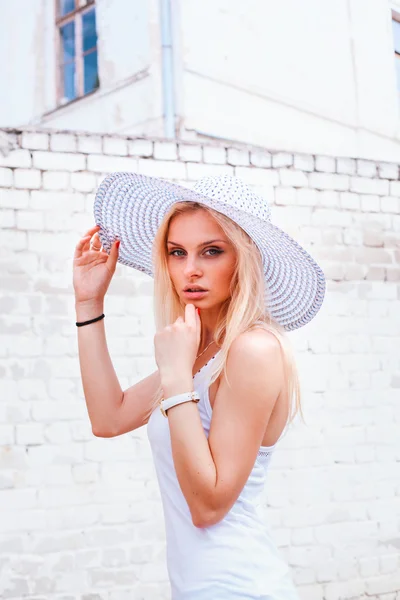 Portrét módní dívka s kloboukem na hlavě nad bílým pozadím — Stock fotografie