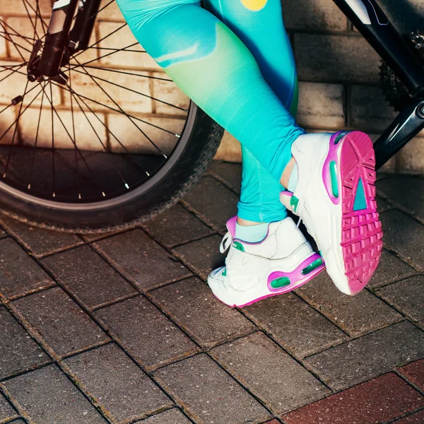 Женщины в кроссовках рядом с велосипедом — стоковое фото