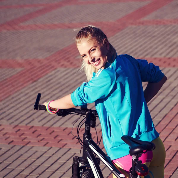 Dziewczyna z rowerów, uśmiechając się i patrząc w aparacie — Zdjęcie stockowe