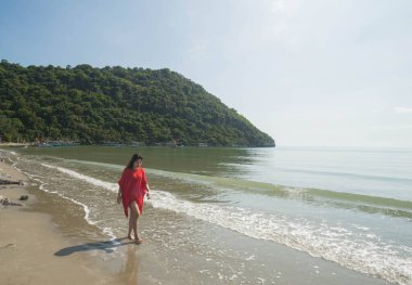 Kumsalda yürüyen bir kadın.