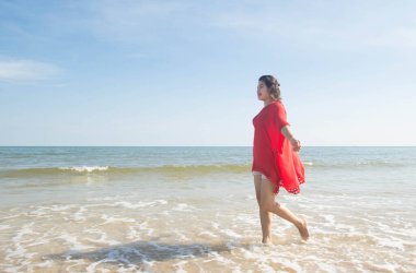 Kumsalda yürüyen bir kadın.