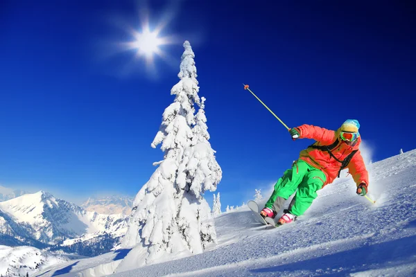 Esquiador esquiando cuesta abajo en las altas montañas — Foto de Stock