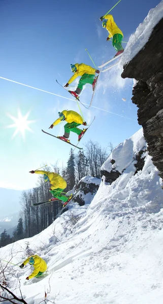 Skifahrer springt gegen blauen Himmel vom Felsen — Stockfoto