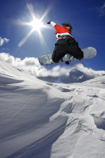 Snowboarder saltando contro il cielo blu — Foto Stock