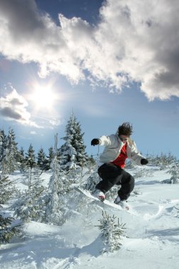 Mavi gökyüzüne atlayan snowboardcu