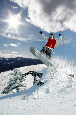 Mavi gökyüzüne atlayan snowboardcu