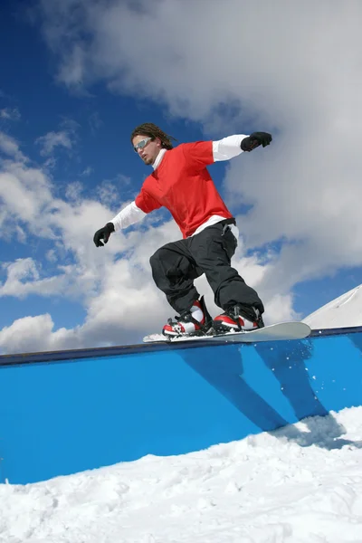 Snowboarder springt gegen blauen Himmel — Stockfoto