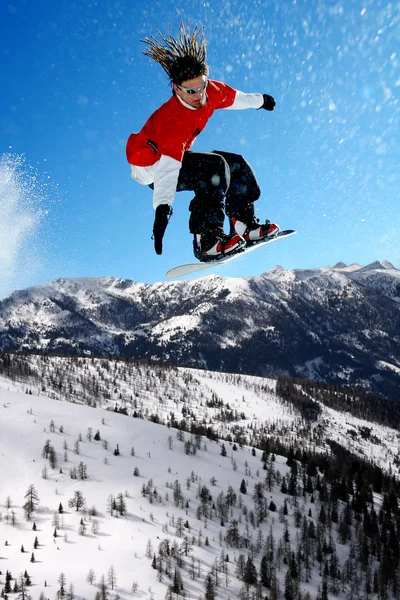 Snowboarder hoppe mod blå himmel - Stock-foto