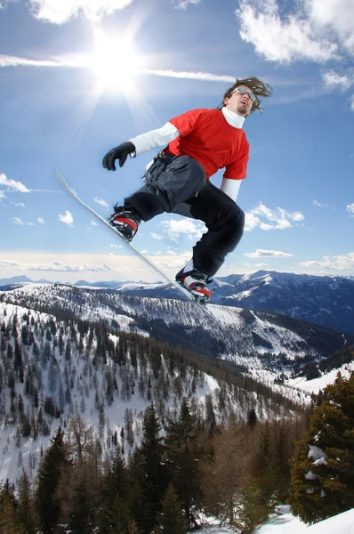 Snowboarder saltando contro il cielo blu — Foto Stock