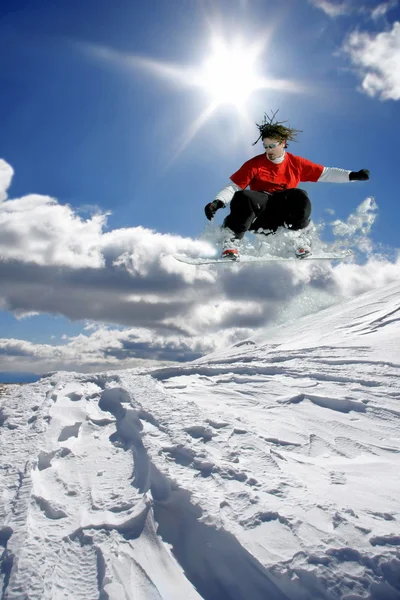 青い空に向かって飛び跳ねるスノーボーダー — ストック写真