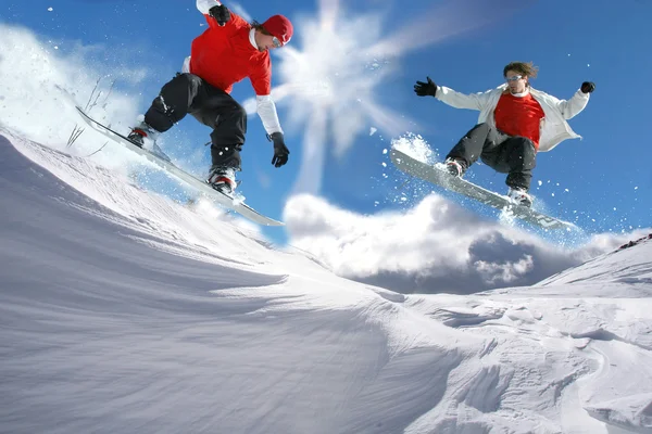 Snowboarders saltando contra el cielo azul —  Fotos de Stock