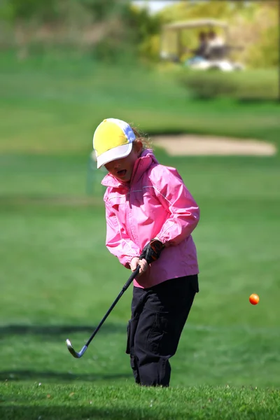 Маленькая девочка играет в гольф durimg весеннее время — стоковое фото