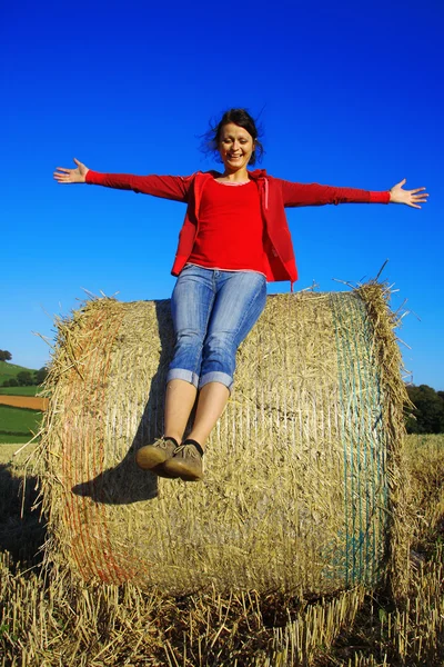 Happy young woman on the straw after the harvest — Stock Photo, Image