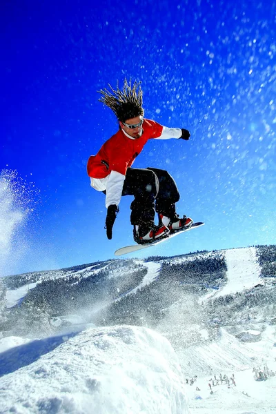 Snowboarders saltando contra el cielo azul — Foto de Stock