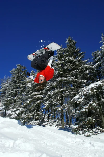 Snowboardisté skoky proti modré obloze — Stock fotografie