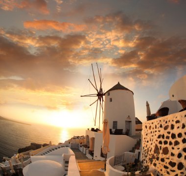 Windmill against colorful sunset, Santorini island in Greece