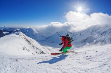 yokuş aşağı güneşli gün boyunca yüksek dağlarda kayak kayakçı