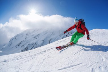 yokuş aşağı güneşli gün boyunca yüksek dağlarda kayak kayakçı