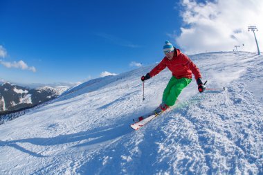yokuş aşağı güneşli gün boyunca yüksek dağlarda kayak kayakçı
