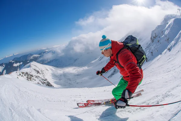 Skier skiing downhill in high mountains during sunny day — Stock Photo, Image