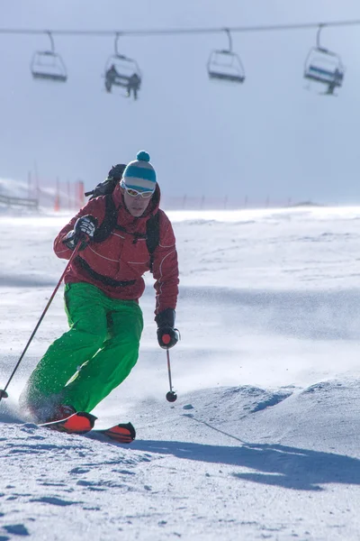 Skiër skiën afdaling in hoge bergen tijdens zonnige dag — Stockfoto