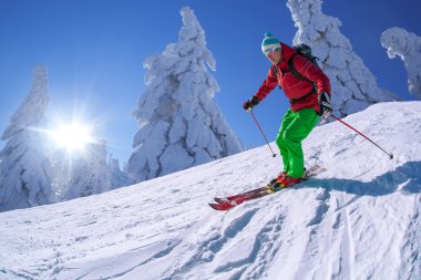 yokuş aşağı güneşli gün boyunca yüksek dağlarda kayak kayakçı